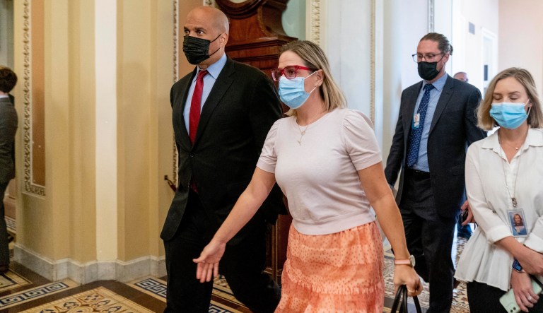 Sen. Cory Booker, D-N.J., and Sen. Kyrsten Sinema, D-Ariz., walk to the Senate Chamber after a Democratic policy meeting at the Capitol in Washington, Tuesday, Oct. 5, 2021.