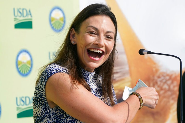 Florida Agriculture Commissioner Nikki Fried smiles as she takes off her mask before speaking at a news conference.