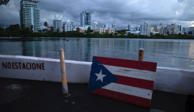 A wooden Puerto Rican flag lies on the shore of the Condado lagoon, where multiple selective blackouts have been recorded in the past days, in San Juan, Puerto Rico, Thursday, Sept. 30, 2021.