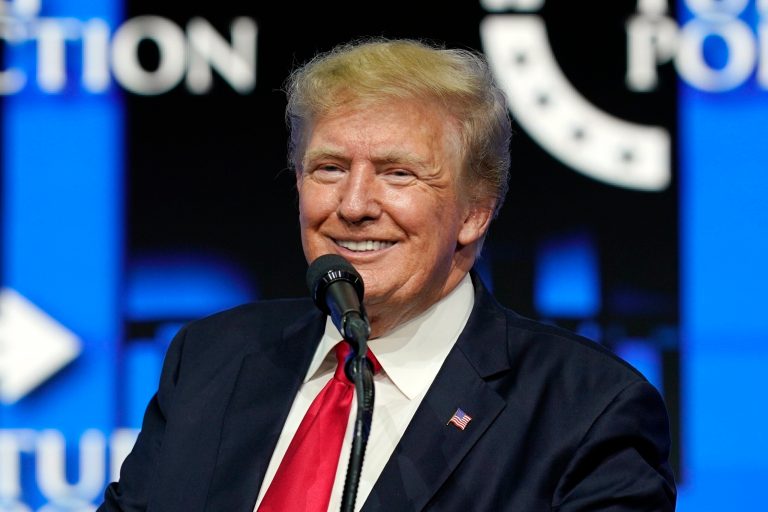 In this July 24, 2021, file photo, former President Donald Trump smiles as he pauses while speaking to supporters at a Turning Point Action gathering in Phoenix. Trump's social media company will be getting tens of millions in special bonus shares in a new publicly traded entity if it performs well, handing the ex-president possibly billions of dollars in paper wealth based on current stock prices, according to a prospectus filed with security regulators on Tuesday, Oct. 26, 2021.