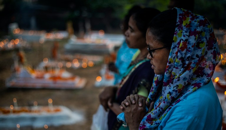 Christians pray at the grave of a deceased relative during All Souls Day in Gauhati, India, Tuesday, Nov. 2, 2021.