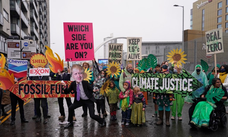 Climate activists take part in a demonstration against the use of fossil fuels outside the COP26 summit in Glasgow. A new study found that flawed renewable energy certificates are undermining corporate climate targets, potentially undermining goals set forth in the 2015 Paris climate accord.
