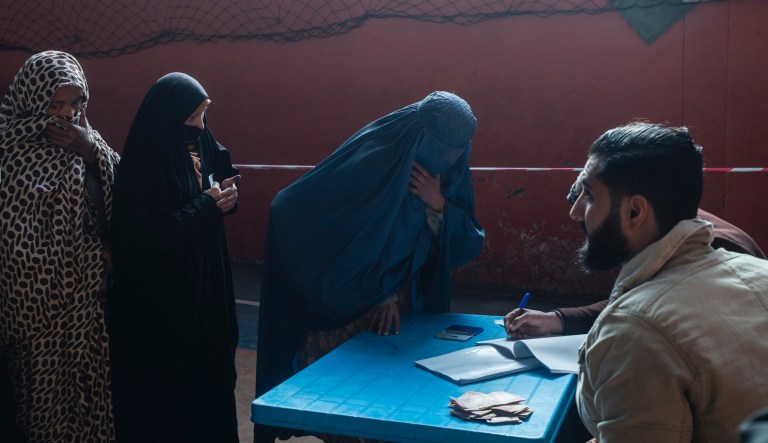 An Afghan woman resisters her name to receive cash at a money distribution center, organized by the World Food Program in Kabul, Afghanistan on Wednesday, Nov. 17, 2021. With the U.N. warning millions are in near-famine conditions, the WFP has dramatically ramped up direct aid to families.