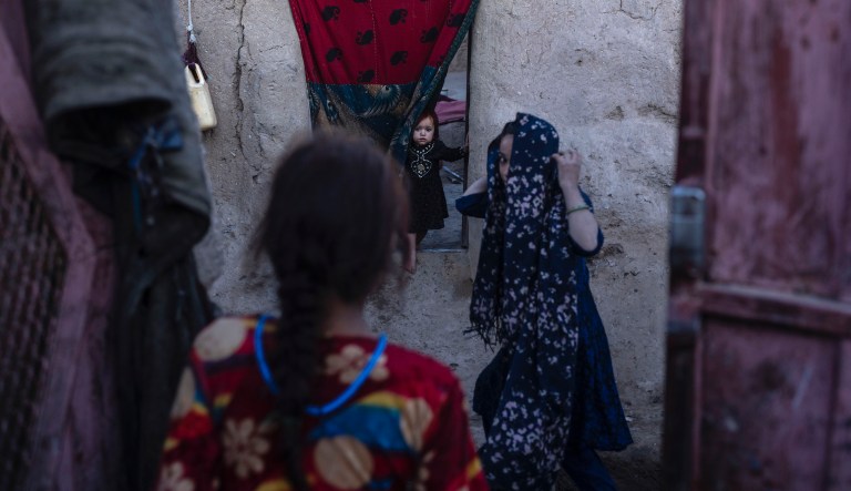 An Afghan girl looks out of her house outskirts of Herat, Afghanistan, Sunday , Nov. 28, 2021.