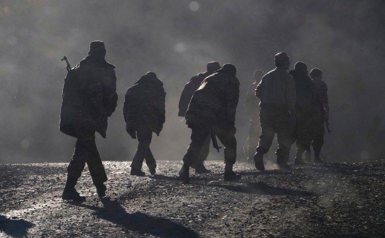 Ethnic Armenian soldiers walk along the road near the border between Nagorno-Karabakh and Armenia.