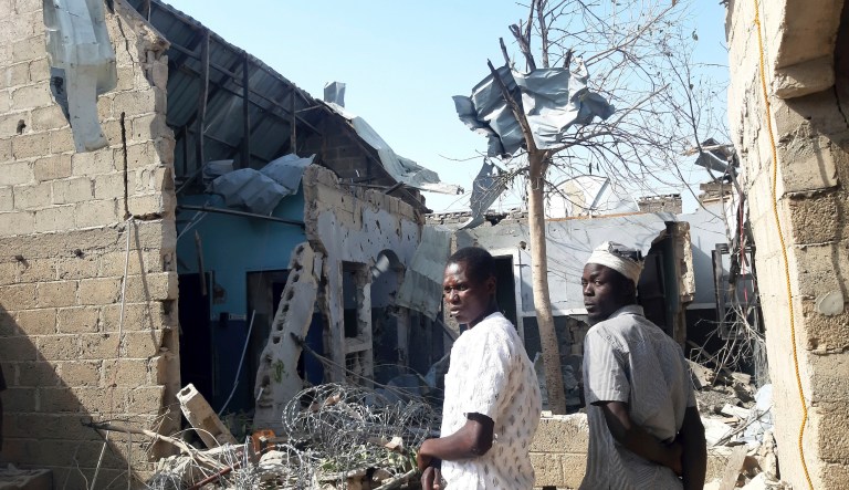 People gather at the scene of an explosion in Maiduguri, Nigeria, Thursday Dec. 23, 2021. An unconfirmed number of persons were killed on Thursday by bomb explosions carried out by extremist rebels in northeast Nigeria, according to witnesses.