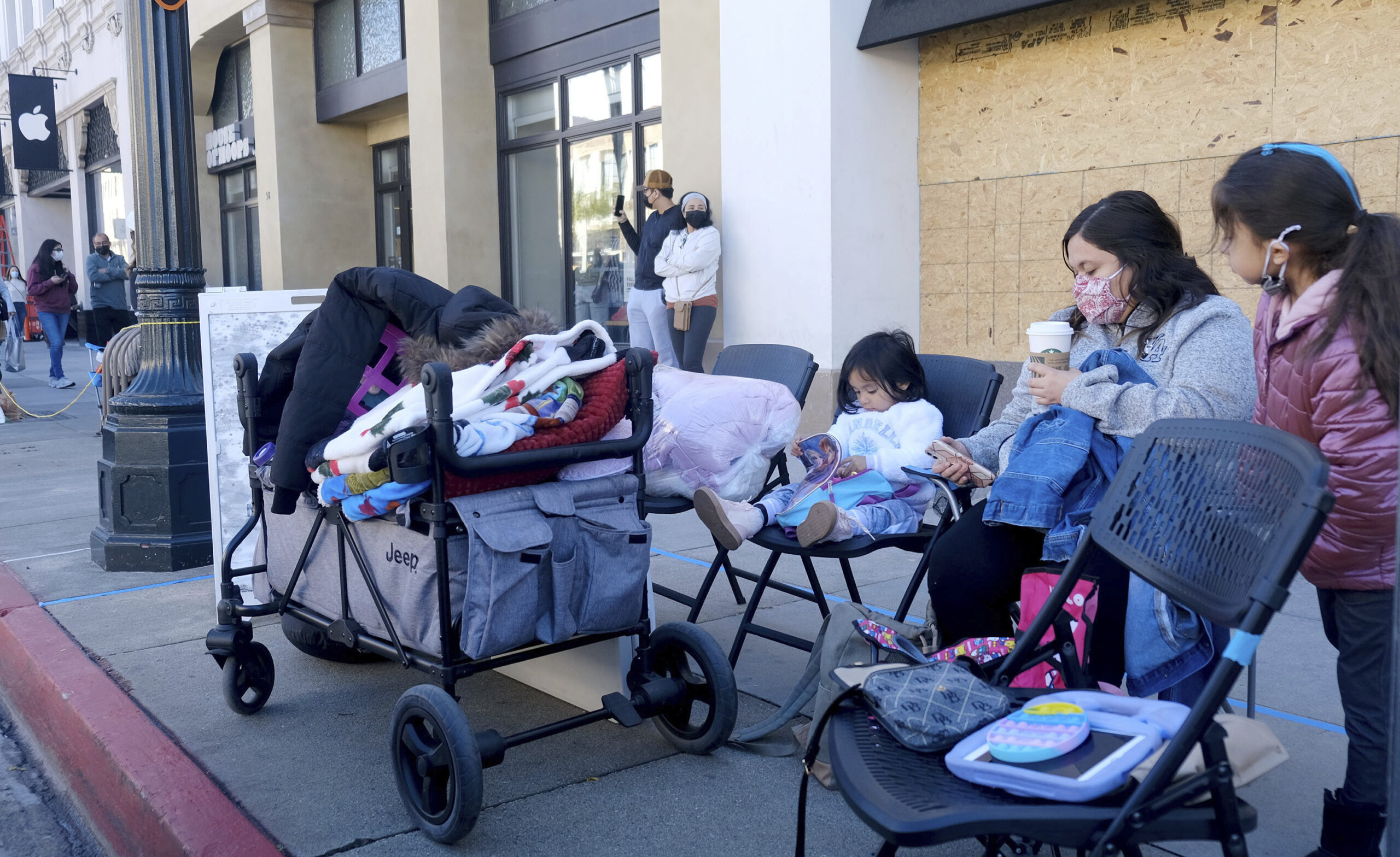 Residents Bryanna Naba and children Janelle 3, and Bella, 8, set up chairs in Pasadena, California, on Friday before the Rose Parade.