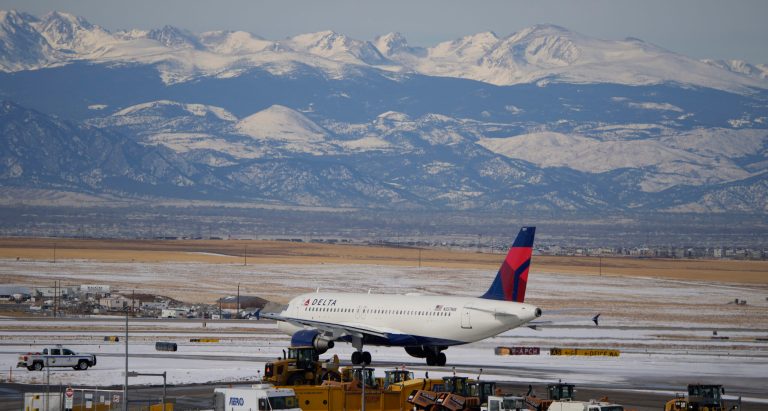 A Delta Airlines plane taxis down a runway Monday, Jan. 3, 2022, in the main terminal of Denver International Airport in Denver. 