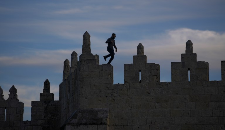 A man walks on top of the Jerusalem Ramparts Walk above Damascus Gate in Jerusalem's Old City, Thursday, Jan. 6, 2022.