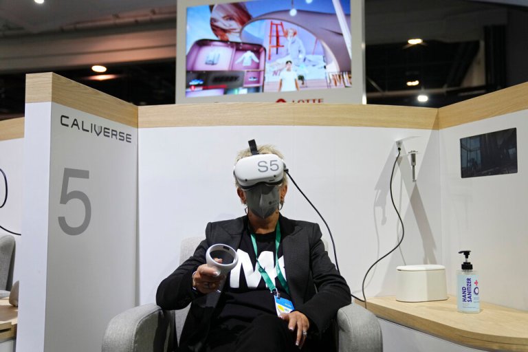 Kelly Taylor tries out a metaverse virtual shopping experience at the LOTTE Data Communication booth during the CES tech show Wednesday, Jan. 5, 2022, in Las Vegas.