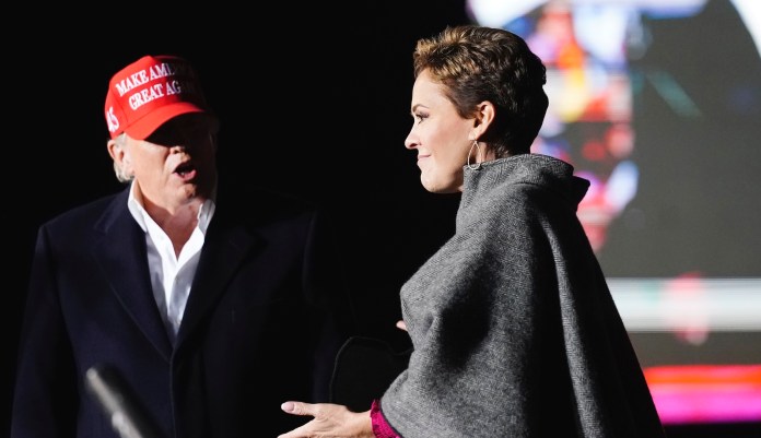 Former President Donald Trump, left, introduces Arizona Republican candidate for governor Kari Lake, right, as Trump speaks at a rally Saturday, Jan. 15, 2022, in Florence, Ariz.