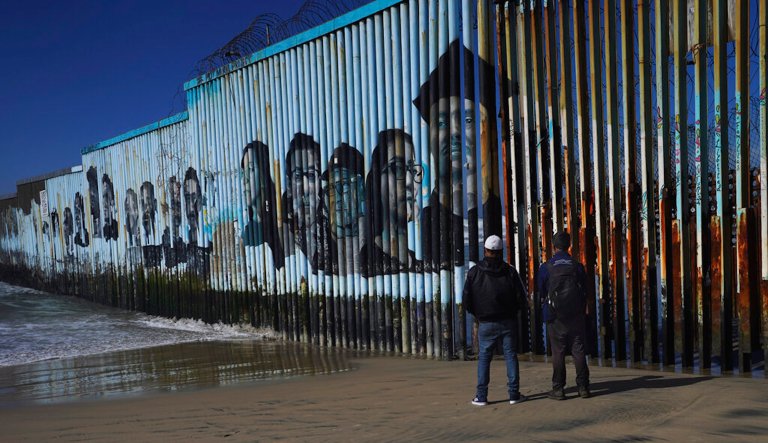 A couple of migrants wait on the Mexican side of the border.