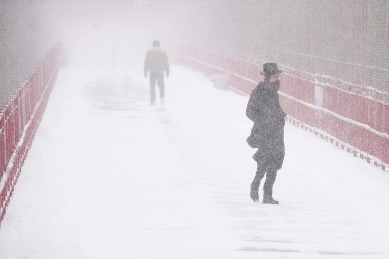 People make their way over the Williamsburg bridge during a snow storm, Saturday, Jan. 29, 2022, in New York. (AP Photo/Mary Altaffer)