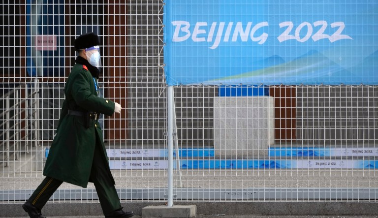 A paramilitary policeman wearing a face shield walks at a screening checkpoint for arriving athletes at the 2022 Winter Olympics, Monday, Jan. 31, 2022, in the Yanqing district of Beijing.