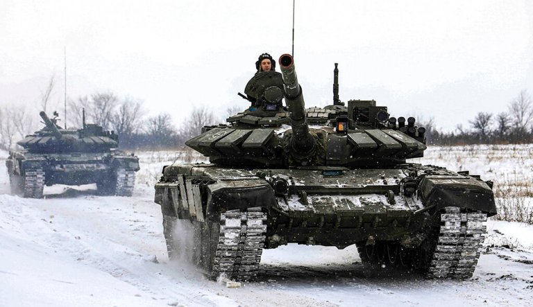 In this photo provided by the Russian Defense Ministry Press Service on Feb. 14, 2022, tanks roll on the field during a military drill in Russia. 