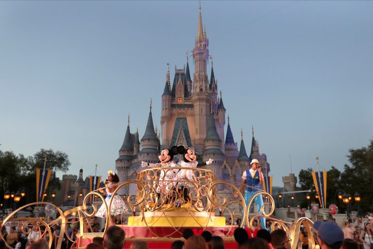 Mickey and Minnie Mouse perform during a parade as they pass by the Cinderella Castle at the Magic Kingdom theme park at Walt Disney World in Lake Buena Vista, Fla.  The theme park resort announced Tuesday, Feb. 15, 2022, that face coverings will be optional for fully-vaccinated visitors in all indoor and outdoor locations, with one exception. Face masks still will be needed for visitors ages 2 and older on enclosed transportation, such as the resort's monorail, buses and the resort's sky gondola.