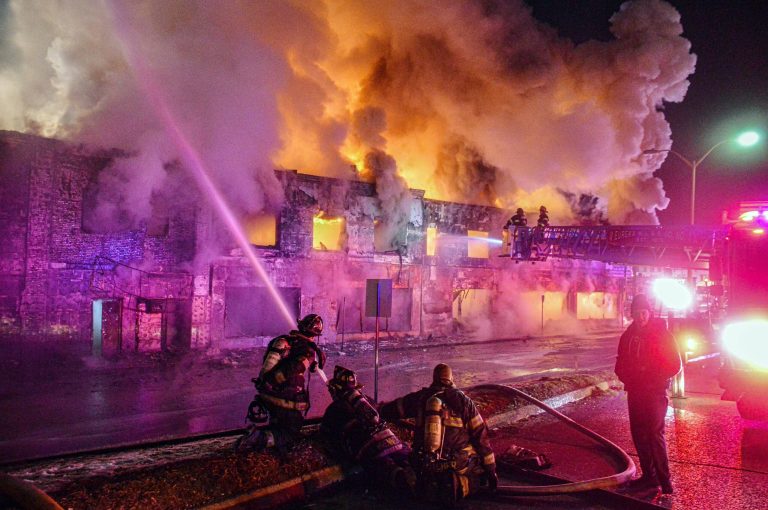 A tanker carrying gasoline lost control, crashed into a vacant building, and burst into flames on Long Island early Wednesday, injuring the truck's driver and three firefighters who responded, authorities said. 