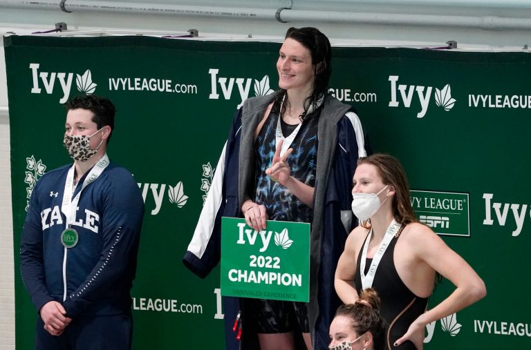Lia Thomas, center, stands on the podium following a medal ceremony after Thomas won the 100-yard freestyle.