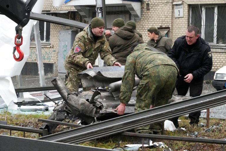 Workers prepare to load the debris of a rocket onto a truck in the aftermath of Russian shelling in Kyiv, Ukraine, Thursday.