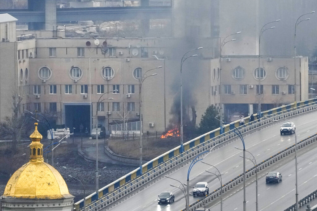 Smoke and flame rise near a military building 