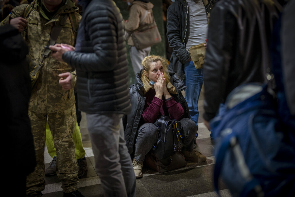 Woman reacts as she waits for a train trying to leave Kyiv