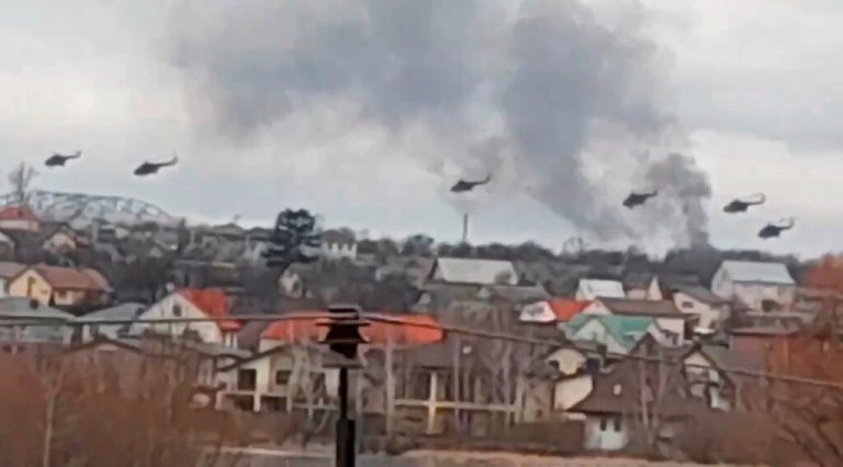 In this handout photo taken from video released by Ukrainian Police Department Press Service, military helicopters apparently Russian, fly over the outskirts of Kyiv, Ukraine, Thursday.