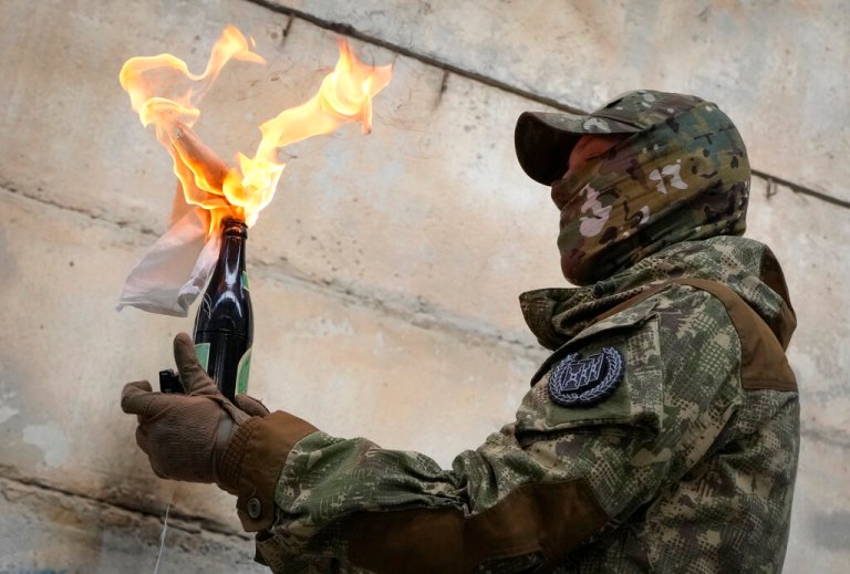 A local resident prepares to use a Molotov cocktail against a wall during an all-Ukrainian training campaign 