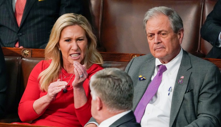 Rep. Marjorie Taylor Greene, a Georgia Republican, talks as Rep. Ralph Norman, a South Carolina Republican, right, listens as President Joe Biden delivers his first State of the Union address to a joint session of Congress at the Capitol in Washington, Tuesday, March 1, 2022.