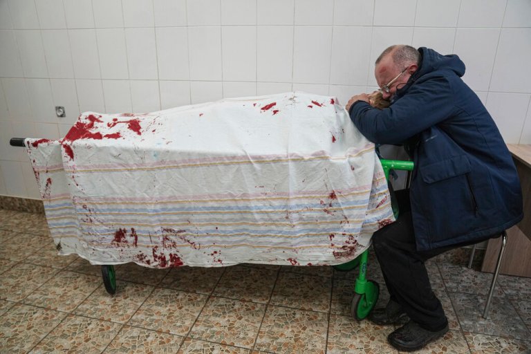 Heartbreaking image shows Ukrainian father mourning son shelled while playing soccer
