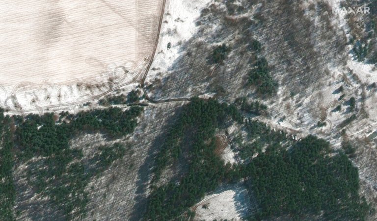This satellite image provided by Maxar Technologies shows troops and equipment deployed in trees and towed artillery in firing position, northwest of Antonov Airport in Lubyanka, Ukraine, during the Russian invasion Thursday.