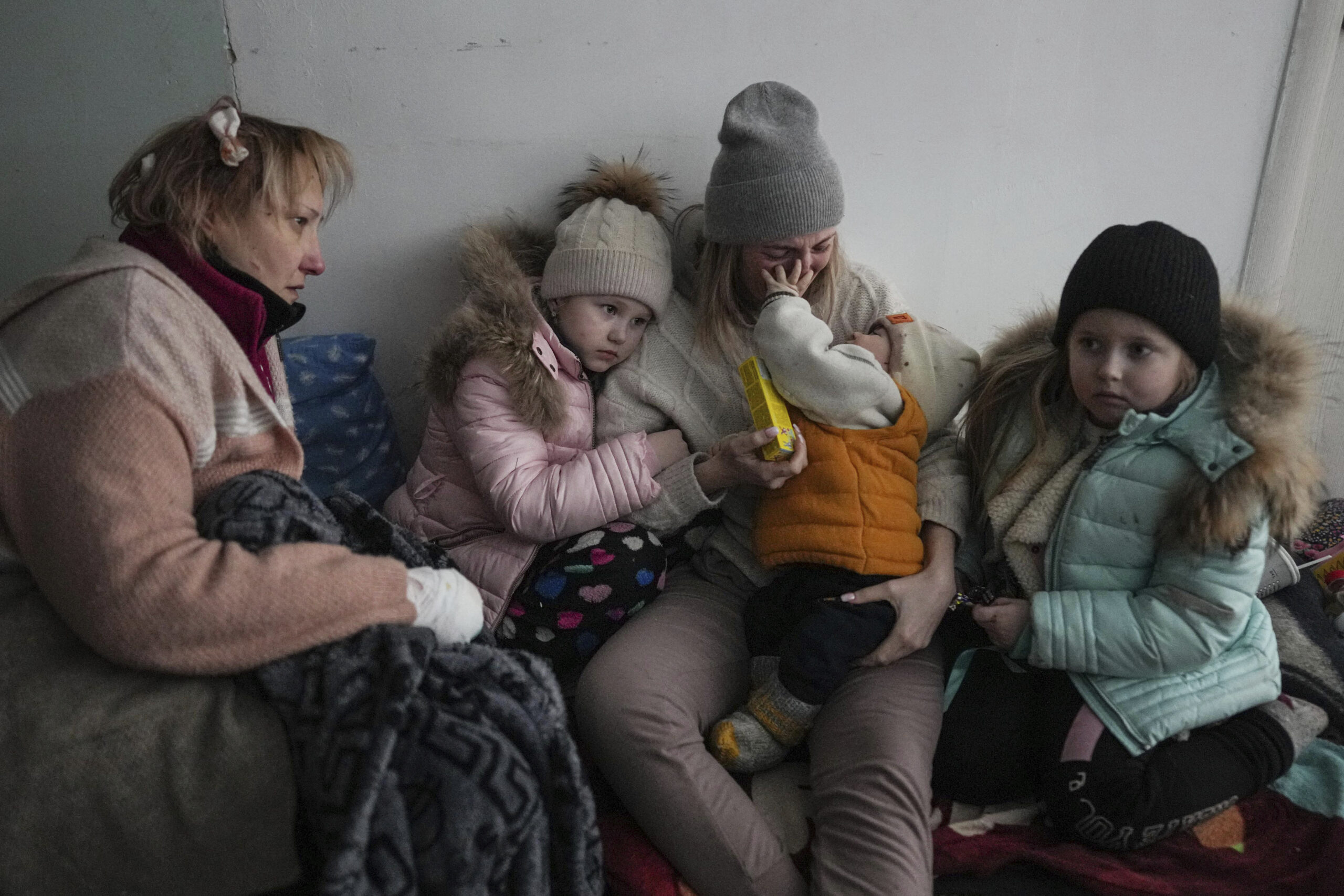 Women and children sit on the floor of a corridor in a hospital in Mariupol, eastern Ukraine, on Friday. Mariupol has been under siege for over a week, with no electricity, gas, or water. Repeated efforts to evacuate people from the city of 430,000 have fallen apart as humanitarian convoys come under shelling. 