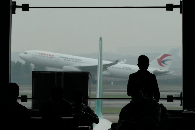 A passenger looks on as a China Eastern flight takes off from the runway of Baiyun Airport on Friday, March 25, 2022, in southern China's Guangzhou province. China Eastern, one of China's four major airlines, said Thursday the Shanghai-based carrier and its subsidiaries have grounded a total of 223 Boeing 737-800 aircraft while they investigate possible safety hazards after the crash of its flight MU5735 on Monday.