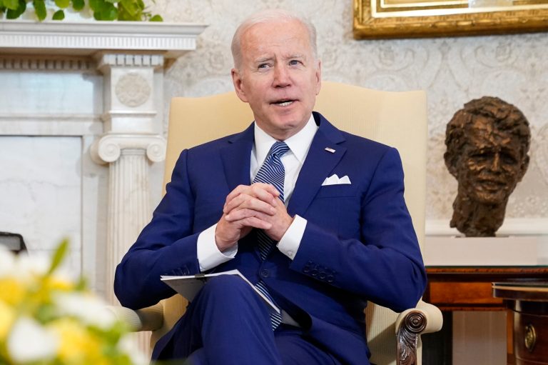 President Joe Biden sits in the Oval Office.