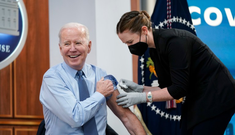 President Joe Biden smiles after receiving his second COVID-19 booster shot in the South Court Auditorium on the White House campus in Washington.  