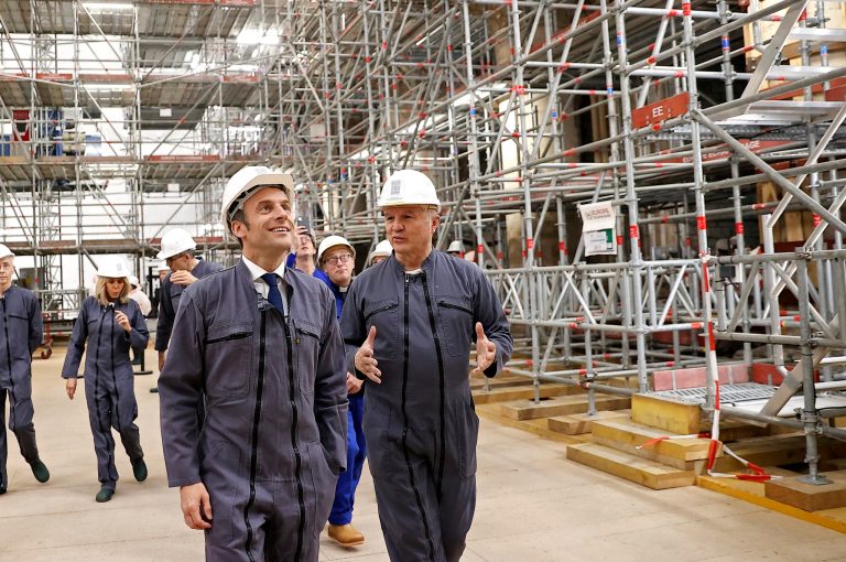 French President Emmanuel Macron, left, listens to French Army General Jean-Louis Georgelin, right, in charge of Notre-Dame Cathedral reconstruction, as he visits the reconstruction site of the Notre-Dame de Paris cathedral, Friday, April 15, 2022 in Paris, to mark three years since the devastating fire.