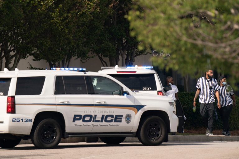 Foot Locker store employees walk near police vehicles outside Columbiana Centre mall in Columbia, South Carolina, following a shooting on Saturday.