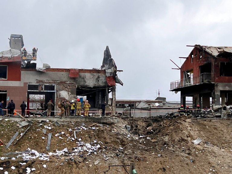 Emergency workers clear up debris after an airstrike hit a tire shop in the western city of Lviv, Ukraine, Monday April 18, 2022.