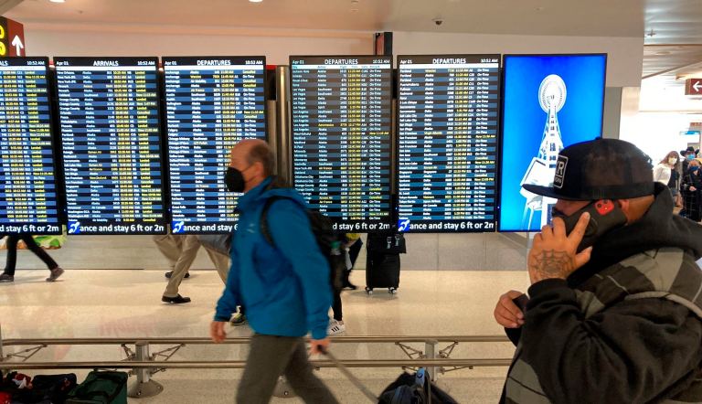 FILE - Travelers walk through Seattle-Tacoma International Airport on Friday, April 1, 2022 in Seattle.