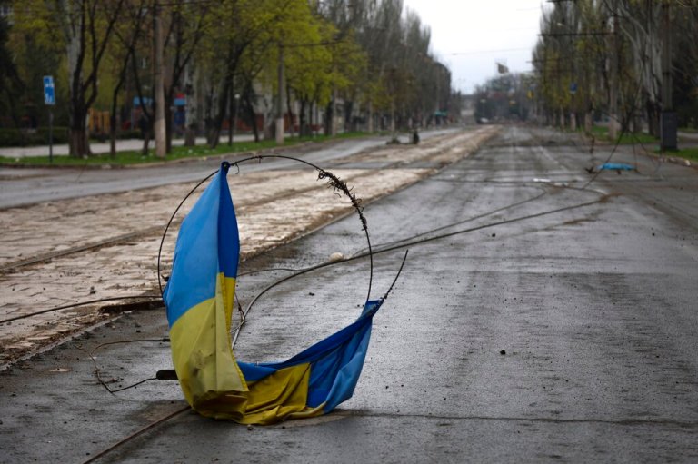A Ukrainian national flag on a wire on the ground in an area controlled by Russian-backed separatist forces in Mariupol, Ukraine, Monday, April 18, 2022.