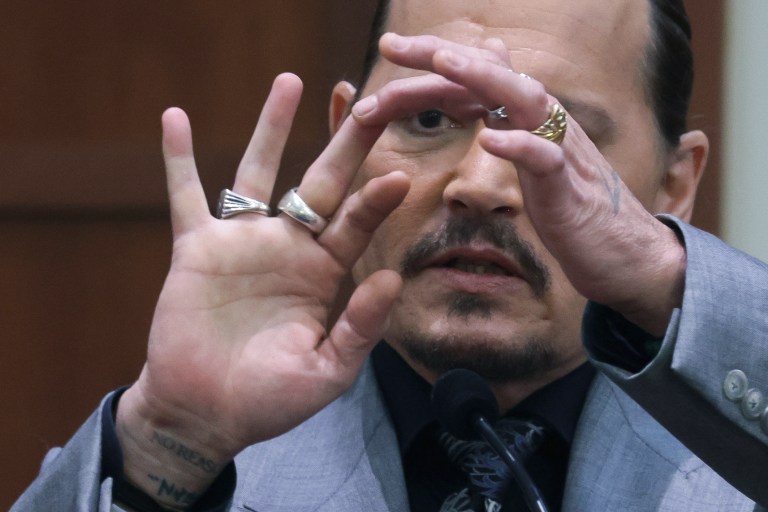 Actor Johnny Depp displays the middle finger of his hand, injured while he and his ex-wife Amber Heard were in Australia in 2015, as he testifies during a hearing in the courtroom at the Fairfax County Circuit Court in Fairfax, Va., Wednesday, April 20, 2022. Actor Johnny Depp sued his ex-wife Amber Heard for libel in Fairfax County Circuit Court after she wrote an op-ed piece in the Washington Post in 2018 referring to herself as a 