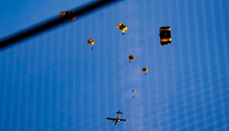 The U.S. Army Parachute Team the Golden Knights jump out of their aircraft before a baseball game between the Washington Nationals and the Arizona Diamondbacks at Nationals Park, Wednesday, April 20, 2022, in Washington.