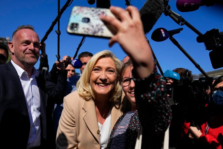 French far-right leader and presidential candidate Marine Le Pen poses for a selfie as she campaigns Friday, April 22, 2022 in Etaples, northern France. Centrist candidate and French President Emmanuel Macron is facing off against far-right challenger Marine Le Pen in France's April 24 presidential runoff.
