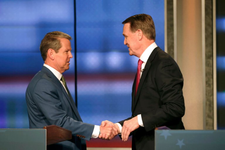 Georgia Gov. Brian Kemp, left, shakes hands with former Sen. David Perdue at a Republican gubernatorial debate, Sunday, April 24, 2022, in Atlanta.