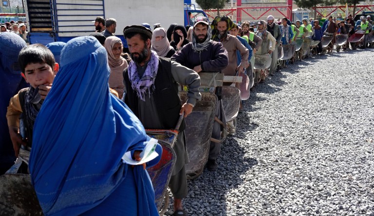 People wait to receive food rations distributed by a Saudi humanitarian aid group, in Kabul, Afghanistan, Monday, April 25, 2022.
