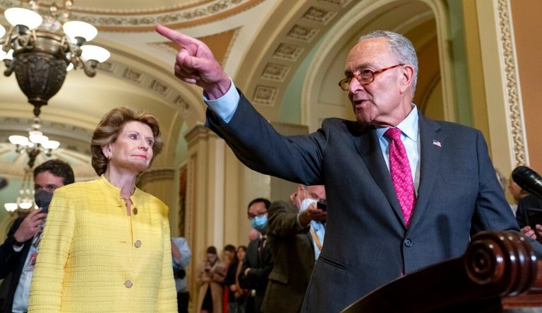 Senate Majority Leader Chuck Schumer, right, calls on a reporter next to Sen. Debbie Stabenow.