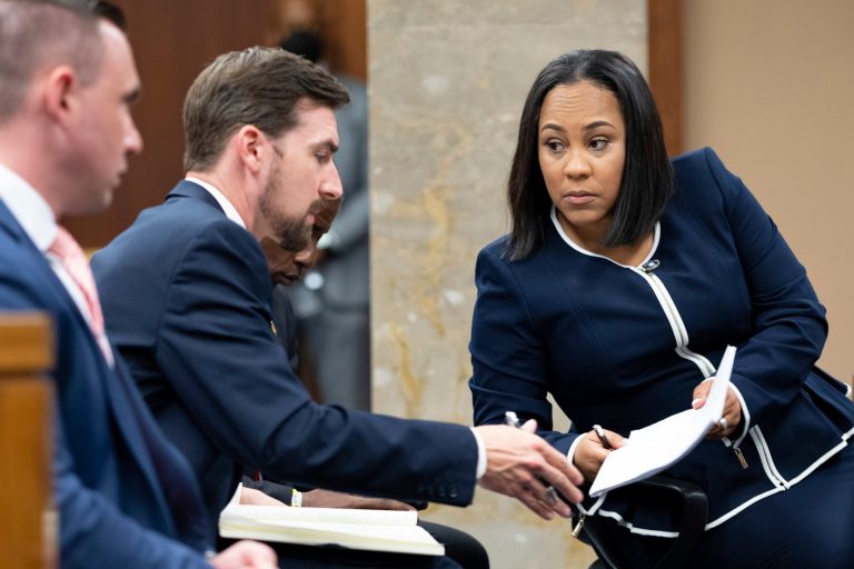 Fulton County District Attorney Fani Willis, right, talks with a member of her team during proceedings to seat a special purpose grand jury in Fulton County, Georgia, on Monday, May 2, 2022, to look into the actions of former President Donald Trump and his supporters who tried to overturn the results of the 2020 election. 