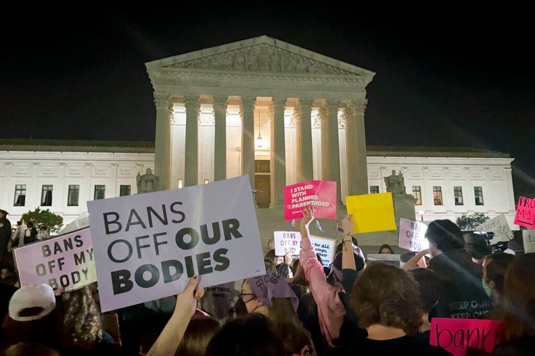 A crowd of people gather outside the Supreme Court, Monday night, May 2, 2022 in Washington. A draft opinion circulated among Supreme Court justices suggests that earlier this year a majority of them had thrown support behind overturning the 1973 case Roe v. Wade that legalized abortion nationwide, according to a report published Monday night in Politico. (AP Photo/Anna Johnson)