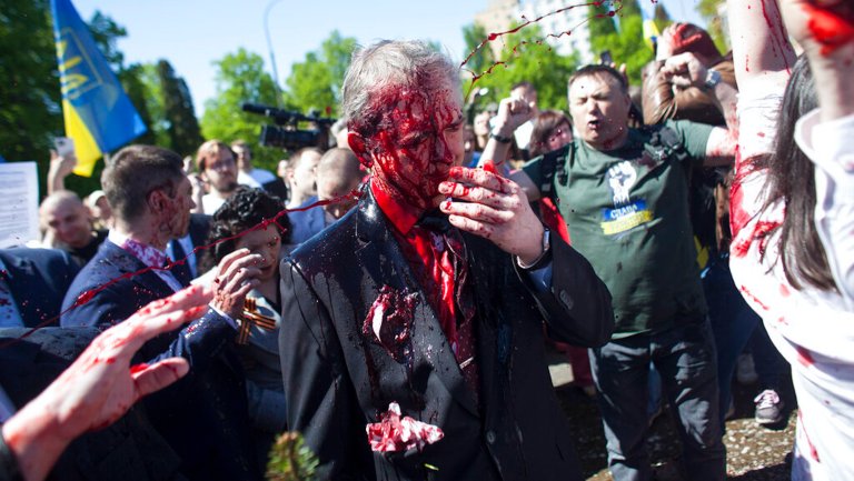 Russian ambassador splattered with red paint by protesters in Poland