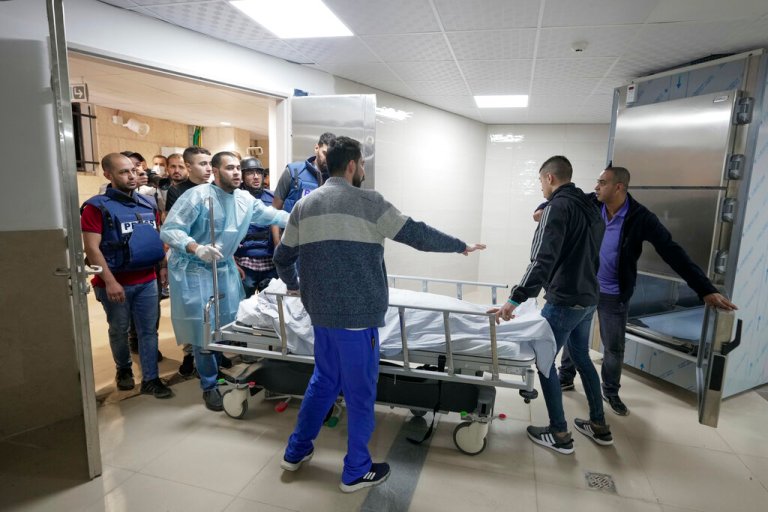 Journalists and medics wheel the body of Shireen Abu Akleh, a journalist for Al Jazeera network, into the morgue inside the Hospital in the West Bank town of Jenin, Wednesday, May 11, 2022. The well-known Palestinian reporter for the broadcaster's Arabic language channel was shot and killed while covering an Israeli raid in the occupied West Bank town of Jenin early Wednesday, the Palestinian health ministry said.