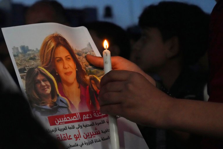 Palestinian holds a light candle and a picture of slain Al Jazeera journalist Shireen Abu Akleh, to condemn her killing, in front of the office of Al Jazeera network, in Gaza City, Wednesday, May 11, 2022. Abu Akleh was shot and killed while covering an Israeli raid in the occupied West Bank town of Jenin.